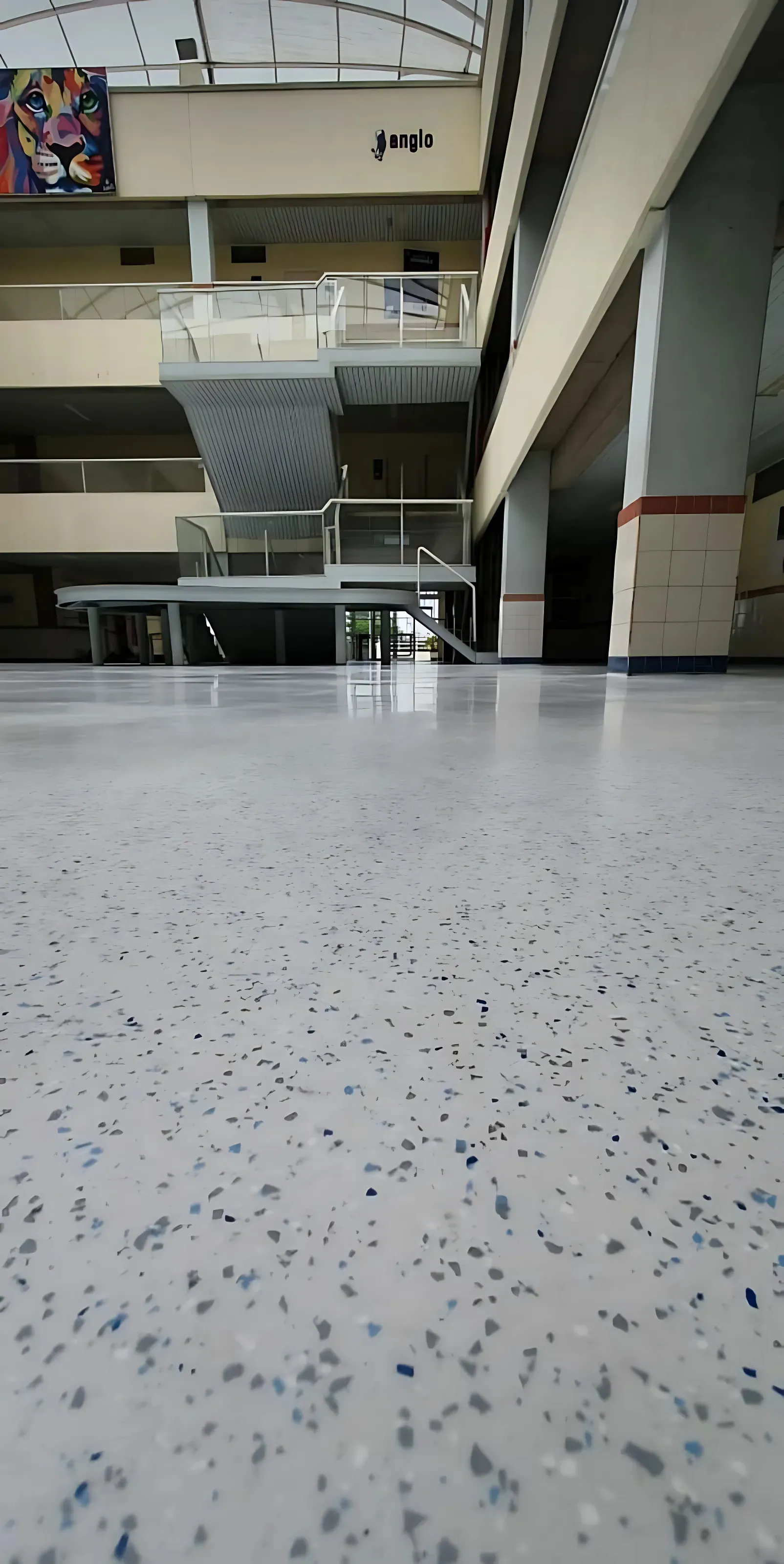Galeria comercial com piso industrial claro e granulado