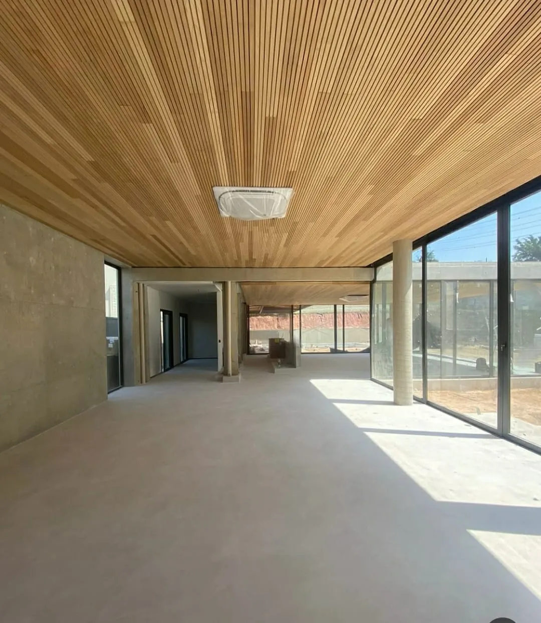 Varanda com piso de microcimento e forro de madeira